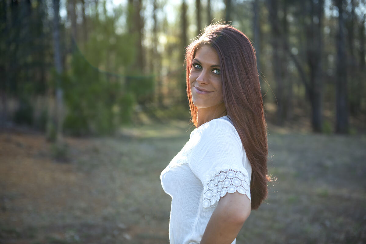 Portrait of a woman in white among tall pines